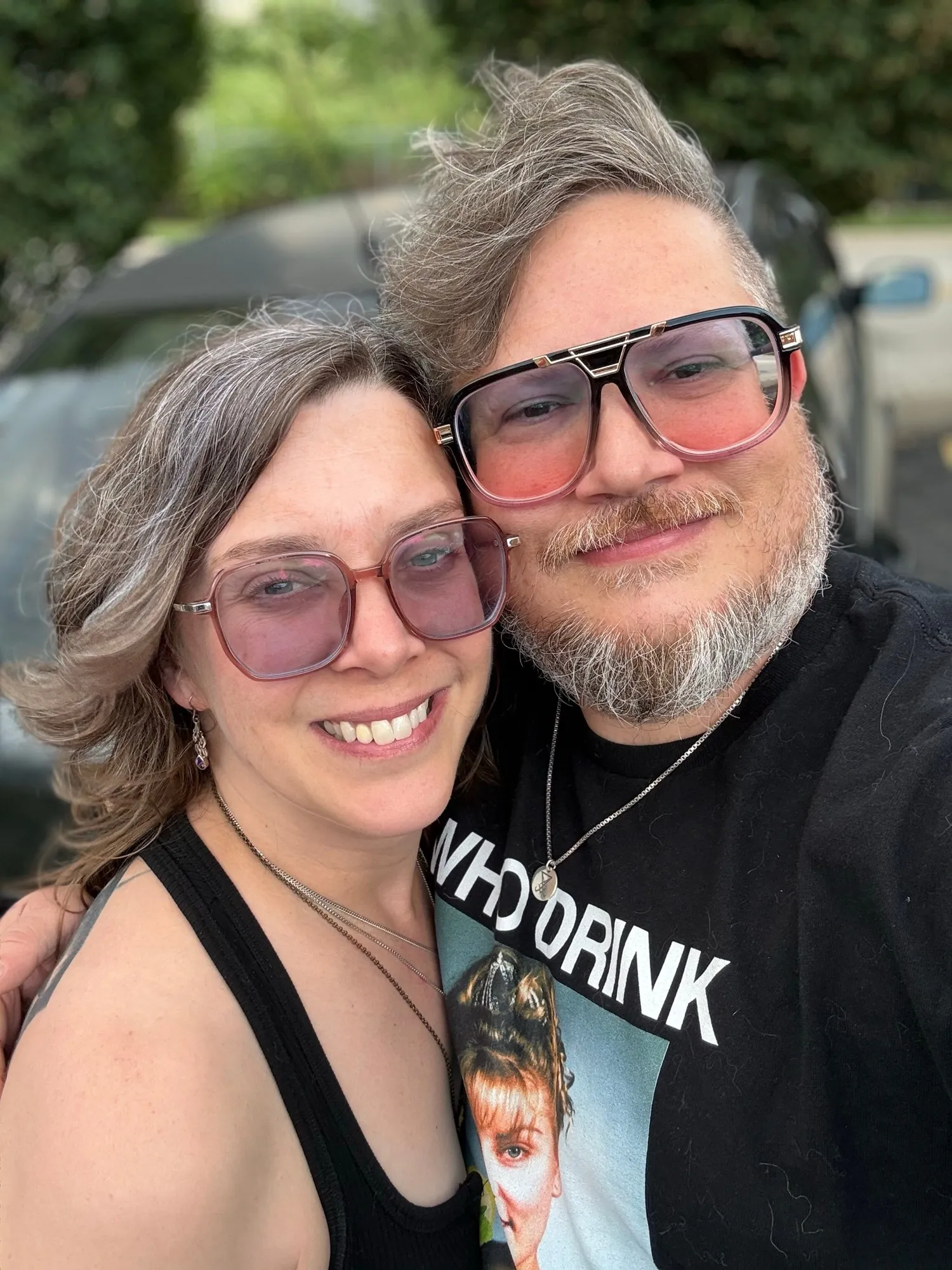 A close-up selfie of us smiling in tinted glasses