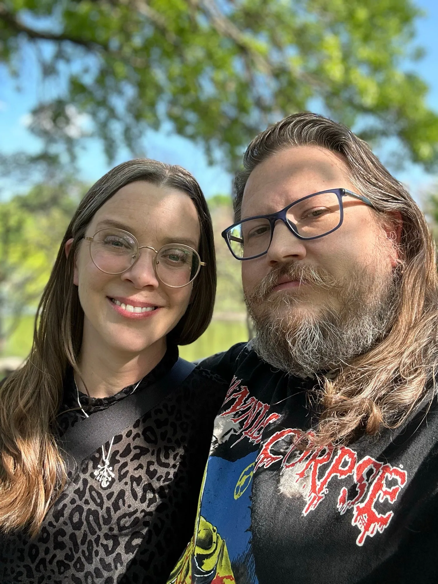 Us smiling under a tree in a sunny park